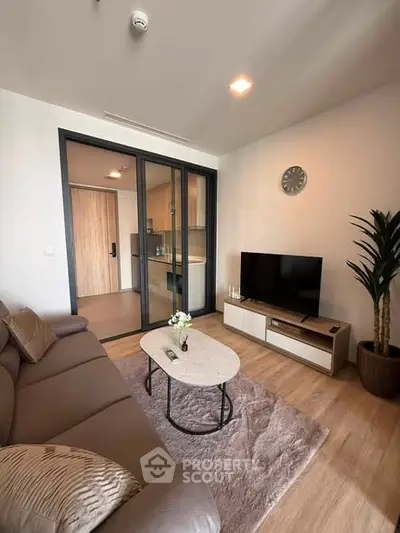 Modern living room with cozy sofa, stylish decor, and open kitchen layout in a contemporary apartment.