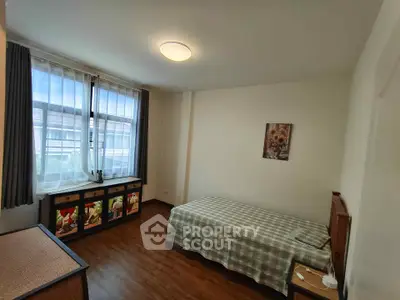Cozy bedroom with single bed and large window, perfect for natural light lovers.