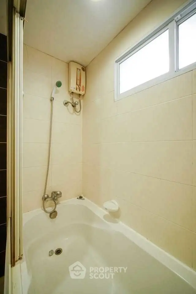Compact bathroom with bathtub and shower, ideal for modern living.