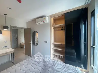 Modern bedroom with built-in wardrobe and air conditioning, featuring sleek design and natural light.