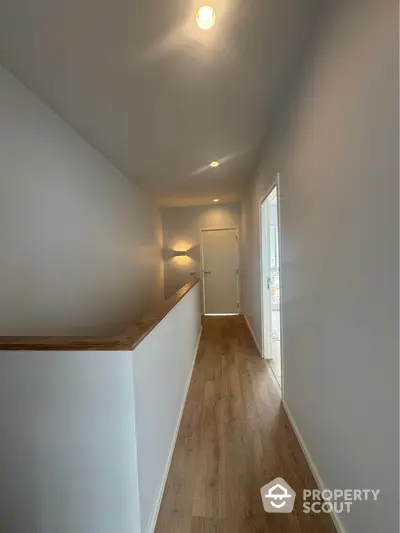 Bright hallway with wooden flooring and modern lighting in a contemporary home.