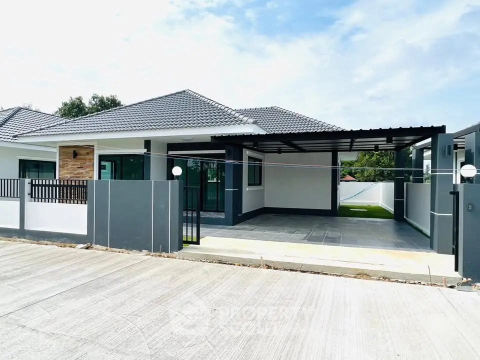 Modern single-story house with spacious driveway and sleek design in a serene neighborhood.