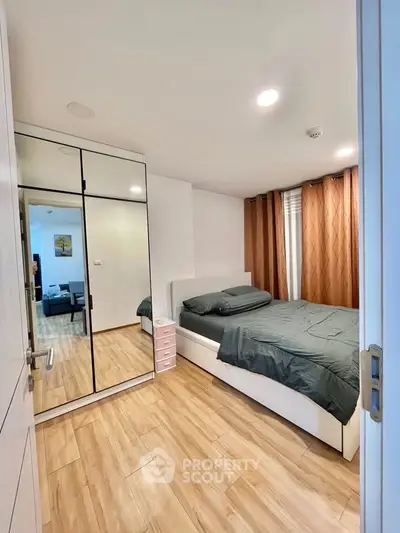 Modern bedroom with mirrored wardrobe and cozy bed in stylish apartment