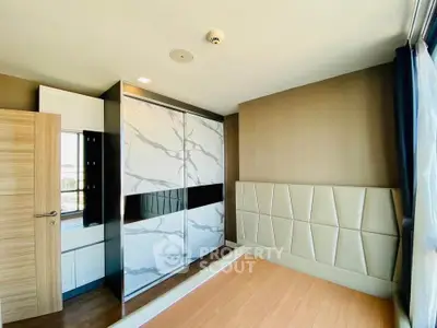 Modern bedroom with stylish wardrobe and large window offering natural light.