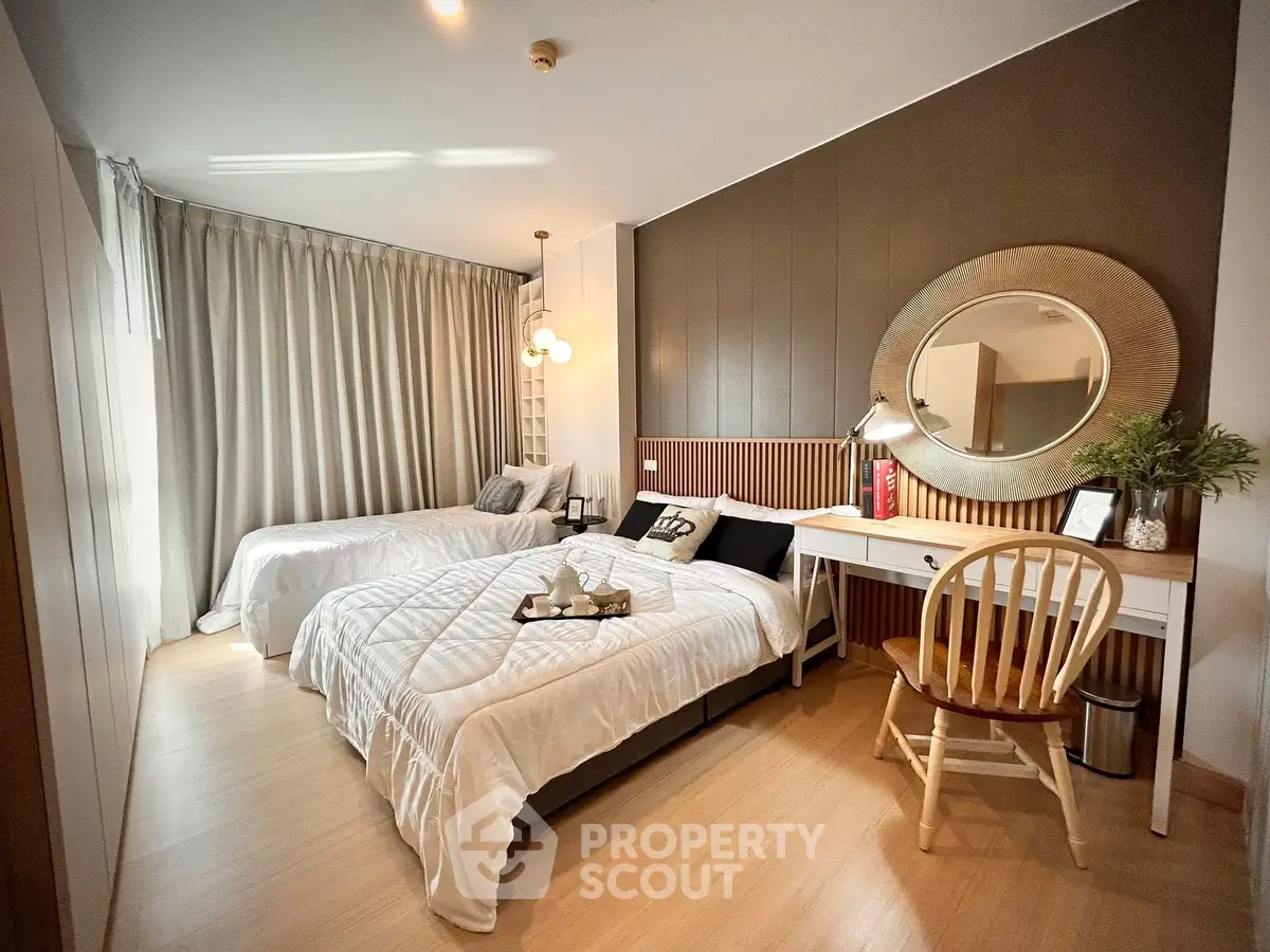 Stylish bedroom with twin beds, elegant decor, and natural light for a cozy living experience.