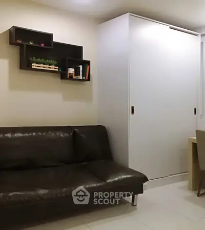 Modern living room with sleek black sofa and minimalist shelving, perfect for urban living.