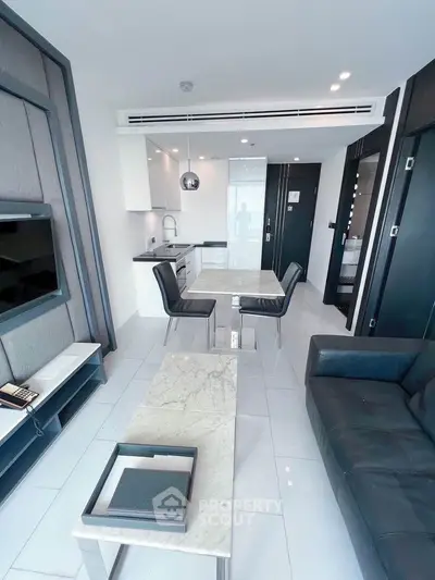 Modern open-plan living room with sleek kitchen and stylish furniture in a luxury apartment.