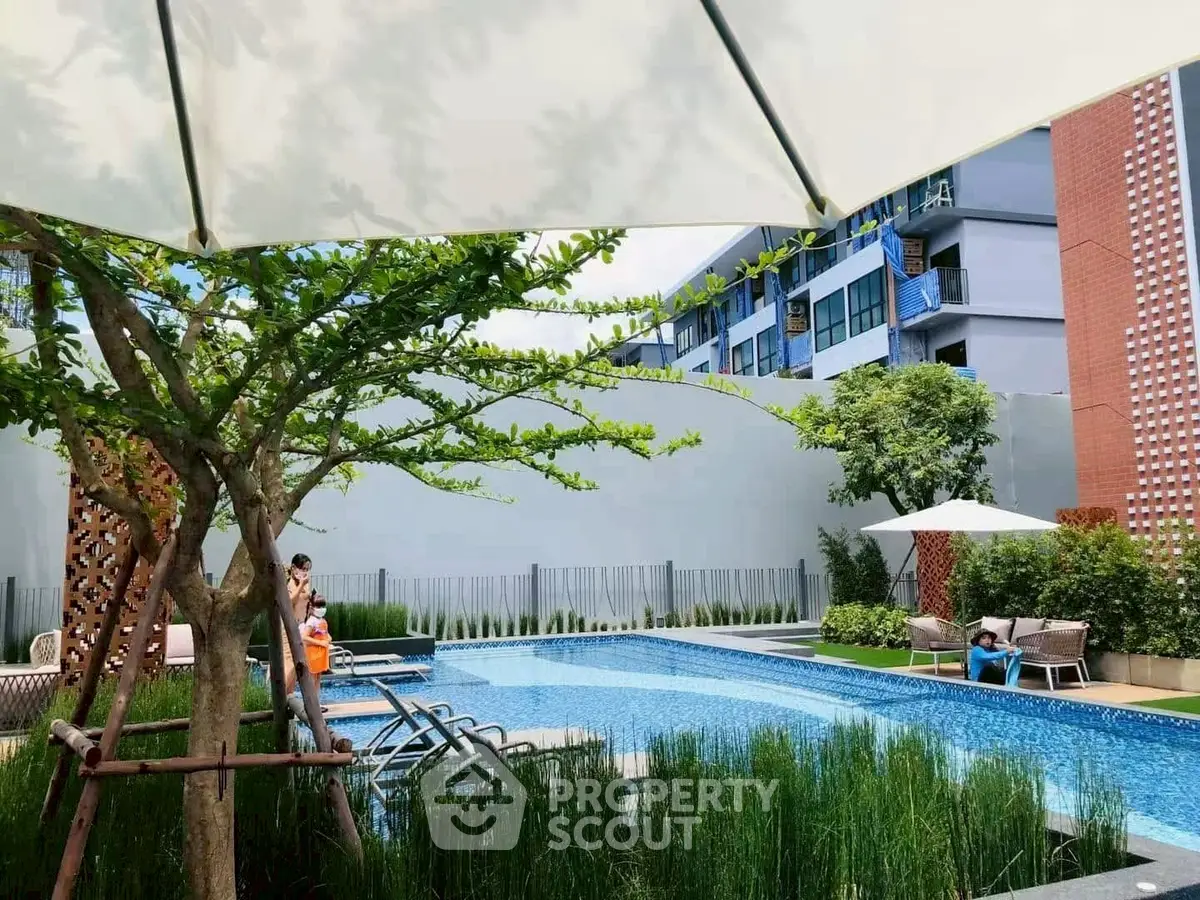 Luxurious apartment complex with serene outdoor pool and lush greenery, perfect for relaxation and leisure.