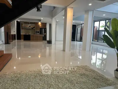 Spacious modern living area with open kitchen and large windows for natural light.