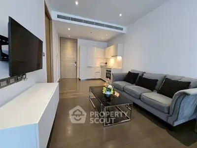 Modern living room with sleek kitchen, cozy sofa, and stylish decor in open layout apartment.