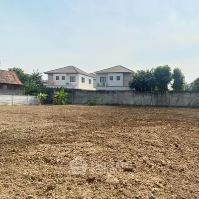 Spacious vacant land plot with potential for development, surrounded by residential homes.