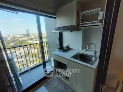 Compact kitchen with balcony view in modern high-rise apartment