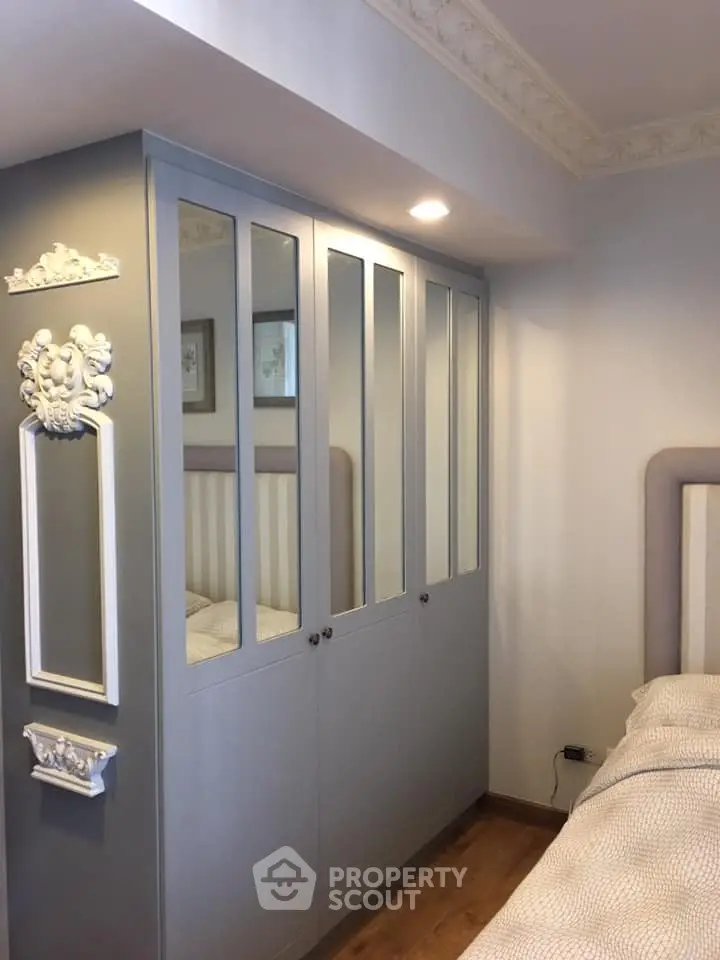 Elegant bedroom with stylish built-in wardrobe and decorative wall accents.
