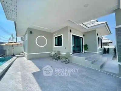 Modern single-story home with pool and stylish outdoor seating area.