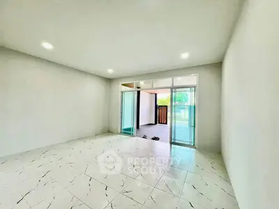 Spacious unfurnished room with tiled flooring and sliding glass doors leading to a balcony.