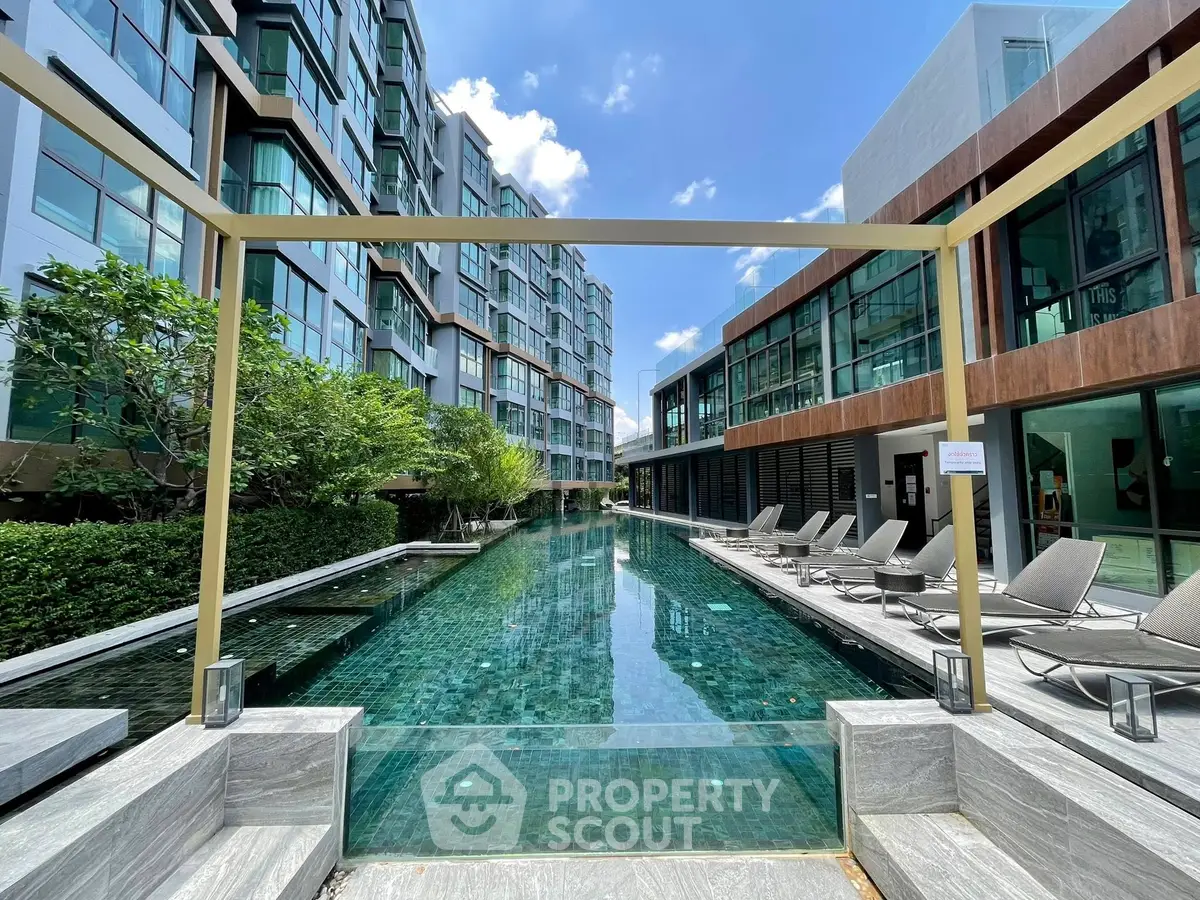 Luxurious modern apartment complex with stunning pool and sun loungers