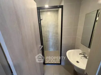 Modern bathroom with sleek shower and elegant sink in contemporary apartment.