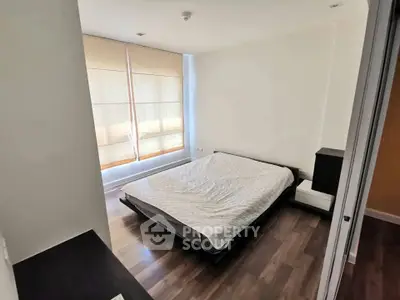 Spacious bedroom with large windows and modern decor in a stylish apartment.
