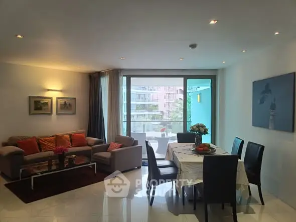 Spacious living and dining area with modern decor and balcony view.