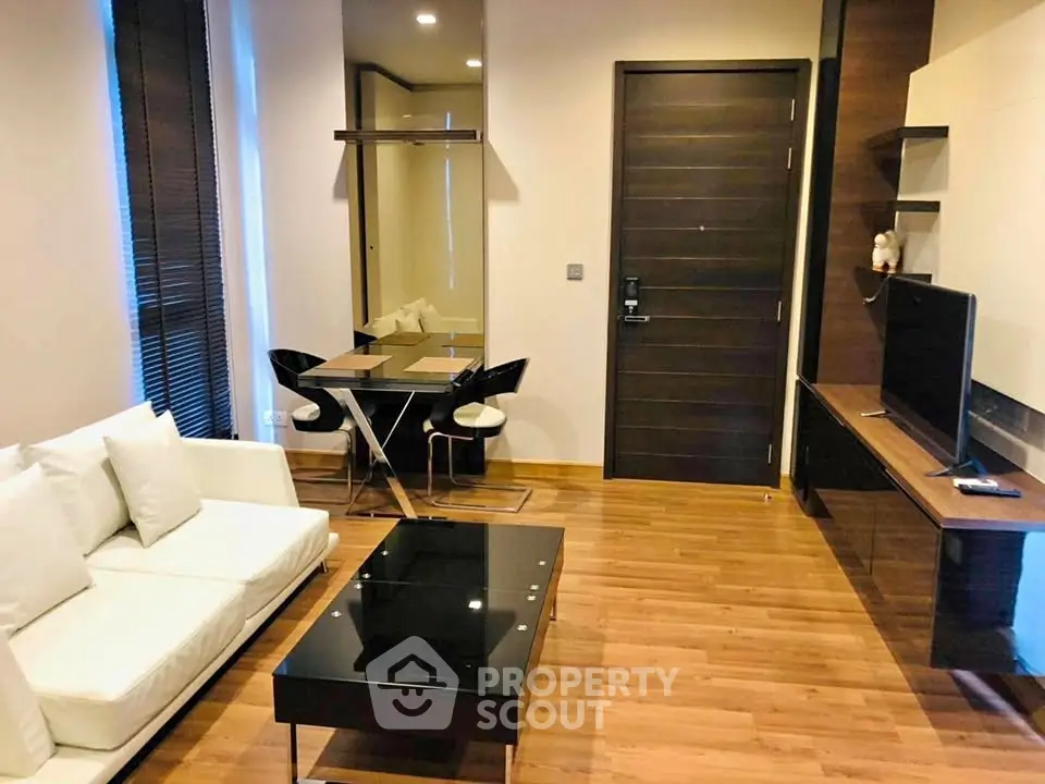 Modern living room with sleek furniture and wooden flooring in a stylish apartment.