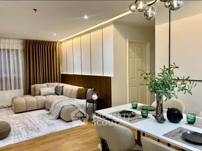 Modern living room with stylish decor and dining area, featuring elegant lighting and cozy seating.