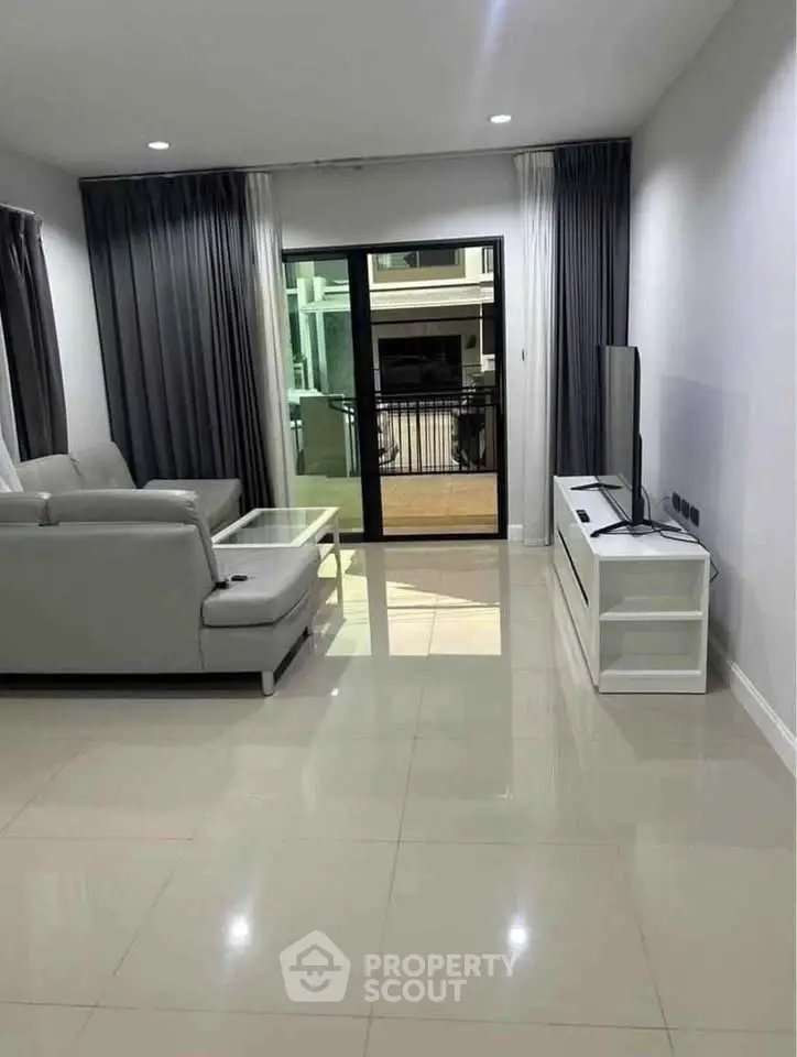 Modern living room with sleek furniture and large windows for natural light.