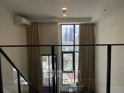 Modern loft apartment with large windows offering stunning city views and natural light.