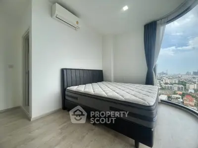 Modern bedroom with city view and large windows in high-rise apartment
