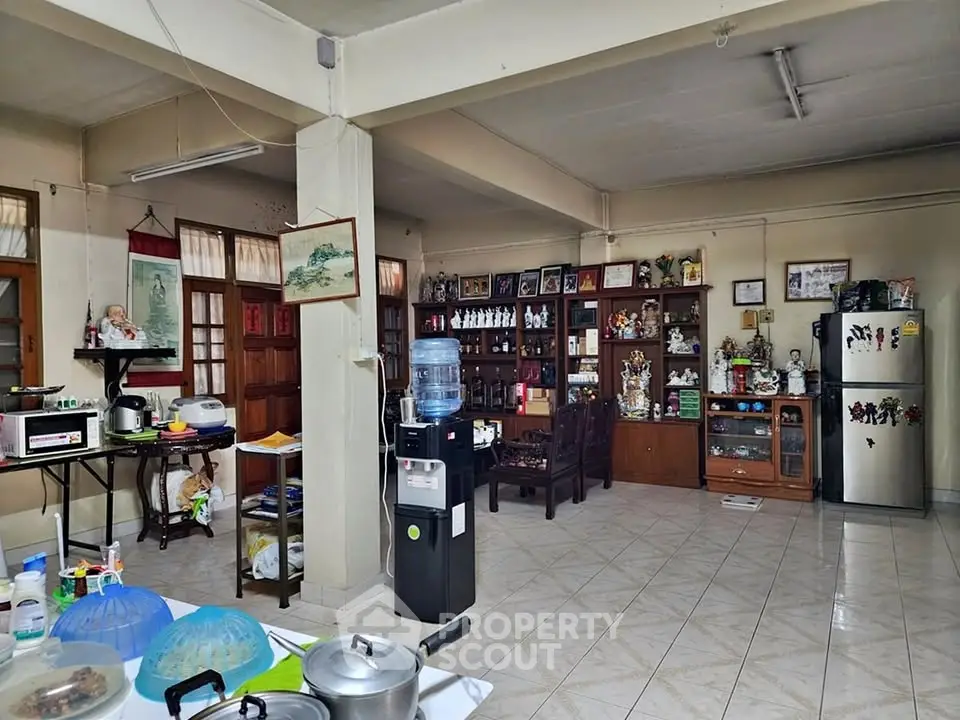 Spacious open-layout living area with kitchen and dining space, featuring tiled floors and ample natural light.