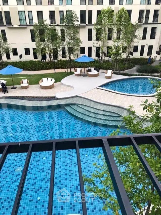 Luxurious apartment complex with stunning pool and landscaped garden view.