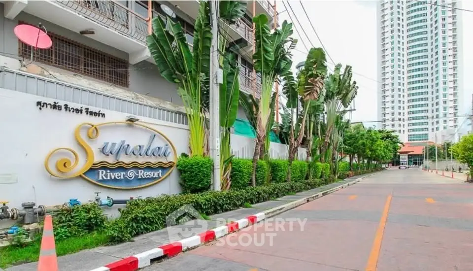 Elegant entrance of Supalai River Resort with lush greenery and modern architecture.