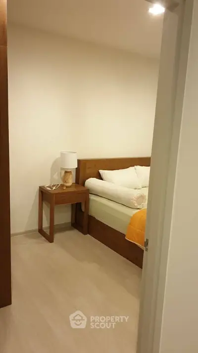 Cozy bedroom with wooden furniture and soft lighting, perfect for relaxation.