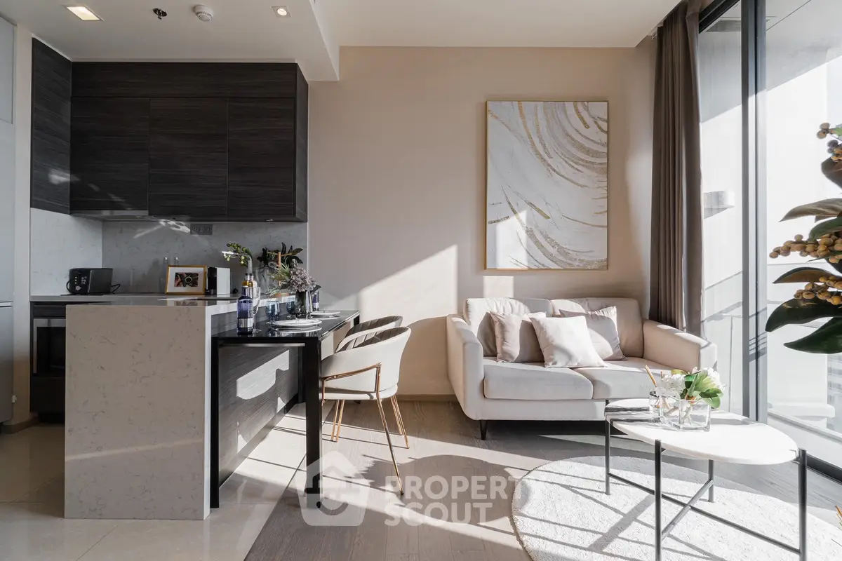 Modern living room with sleek kitchen, elegant decor, and abundant natural light.