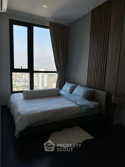 Cozy bedroom with large window offering stunning city view