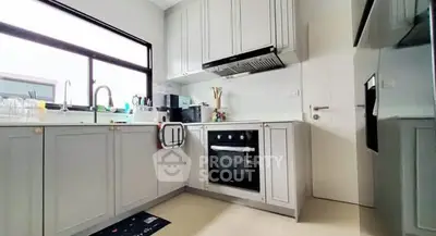 Modern kitchen with sleek cabinetry and built-in oven, featuring a bright and airy design.