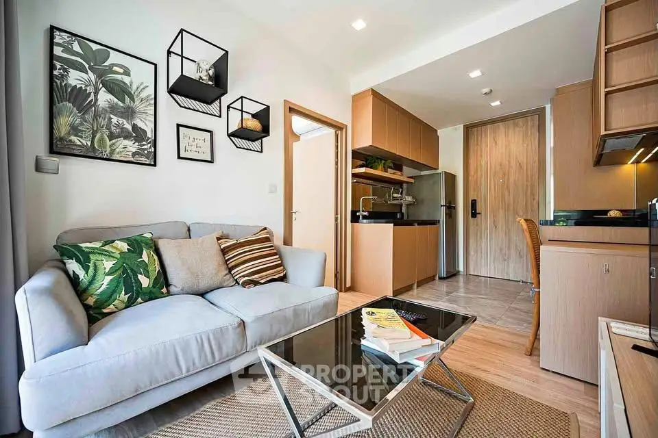 Modern living room with cozy sofa, stylish decor, and compact kitchen in open layout apartment.