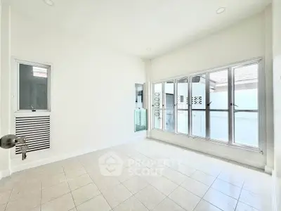 Bright and spacious empty room with large windows and tiled floor, perfect for customization.