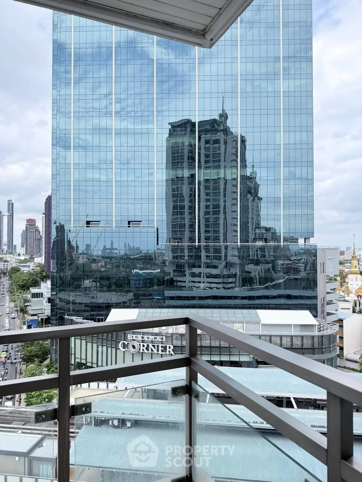Stunning cityscape view from modern balcony with glass railing, perfect for urban living.
