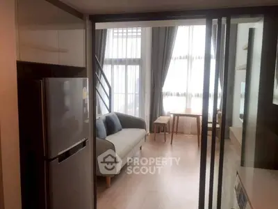 Modern apartment with open layout, featuring a cozy living room and sleek kitchen area.