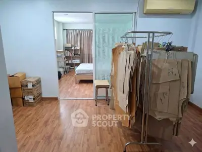 Spacious bedroom with wooden flooring and ample storage space, ideal for creative living.