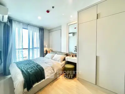 Modern bedroom with large window and stylish decor, featuring built-in wardrobe and cozy ambiance.