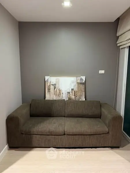 Cozy living room with modern sofa and cityscape artwork, perfect for urban living.