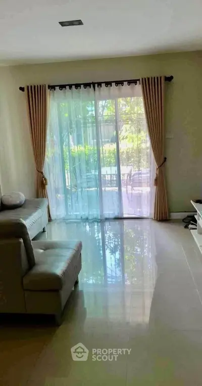 Bright living room with large window and elegant curtains