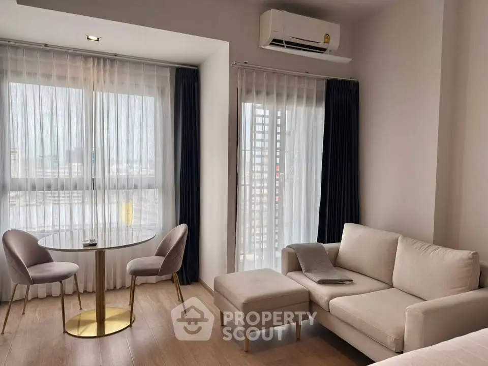 Modern living room with elegant furniture and large windows offering natural light.