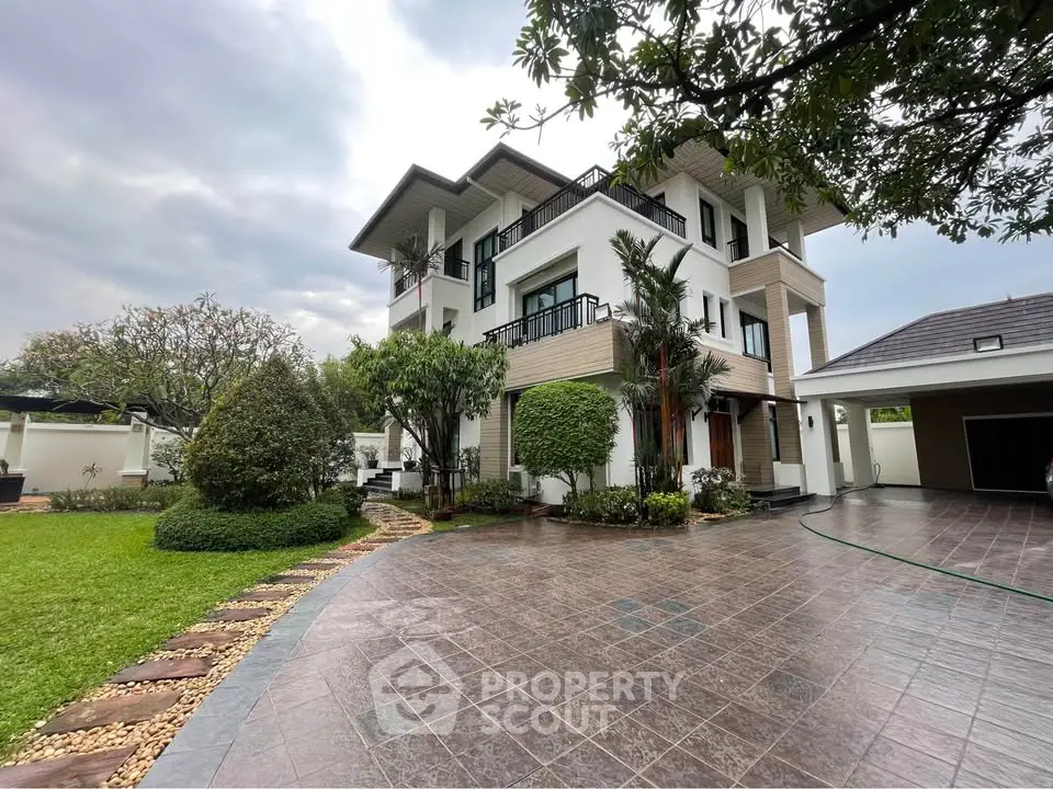 Luxurious modern house with lush garden and spacious driveway, perfect for upscale living.