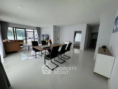 Spacious modern living room with sleek dining area and large windows for natural light.