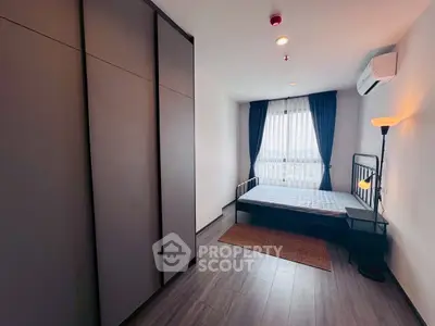 Modern bedroom with large wardrobe and window view, featuring sleek flooring and minimalist decor.