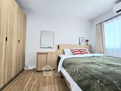 Modern bedroom with wooden furniture and cozy decor in a bright apartment.