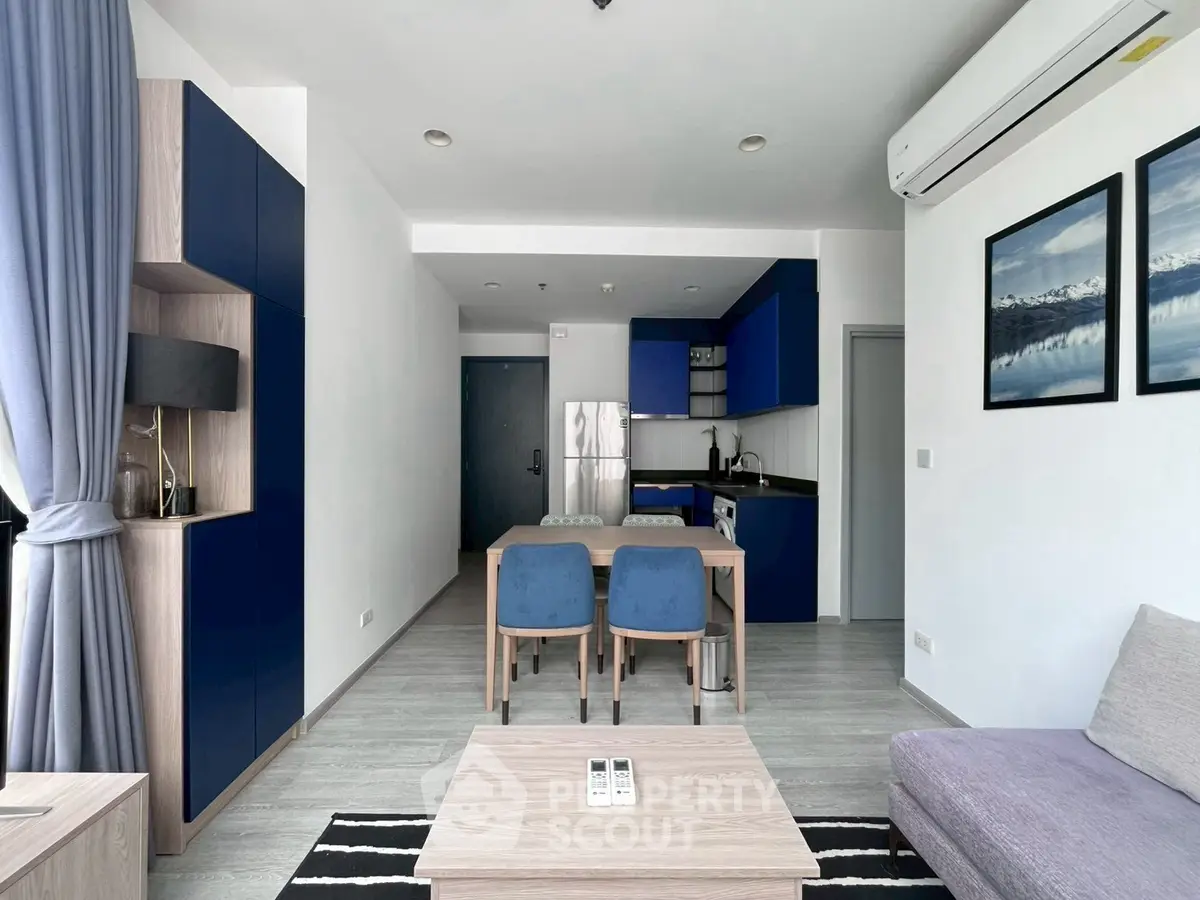 Modern living room with blue accents and open kitchen layout
