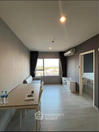 Modern living room with sleek design, large window, and air conditioning unit, perfect for urban living.